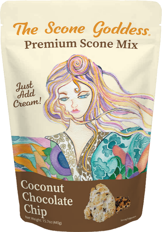 A stand-up pouch of The Scone Goddess Premium Scone Mix, Coconut Chocolate Chip flavor. The packaging features a cream-colored top section with orange and brown text, and a colorful illustration of a woman with flowing hair.